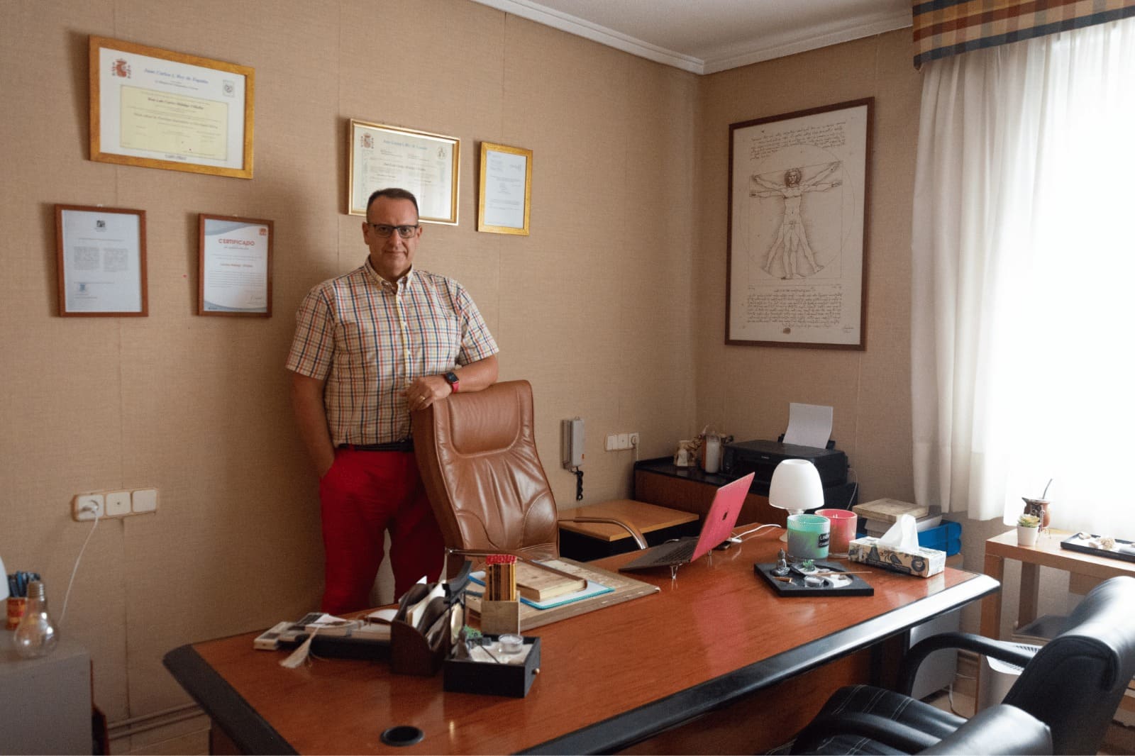 Carlos Hidalgo, psicólogo en Castellón con gran experiencia y formación, de pie al lado de la silla de su despacho donde realiza las sesiones de terapia.
