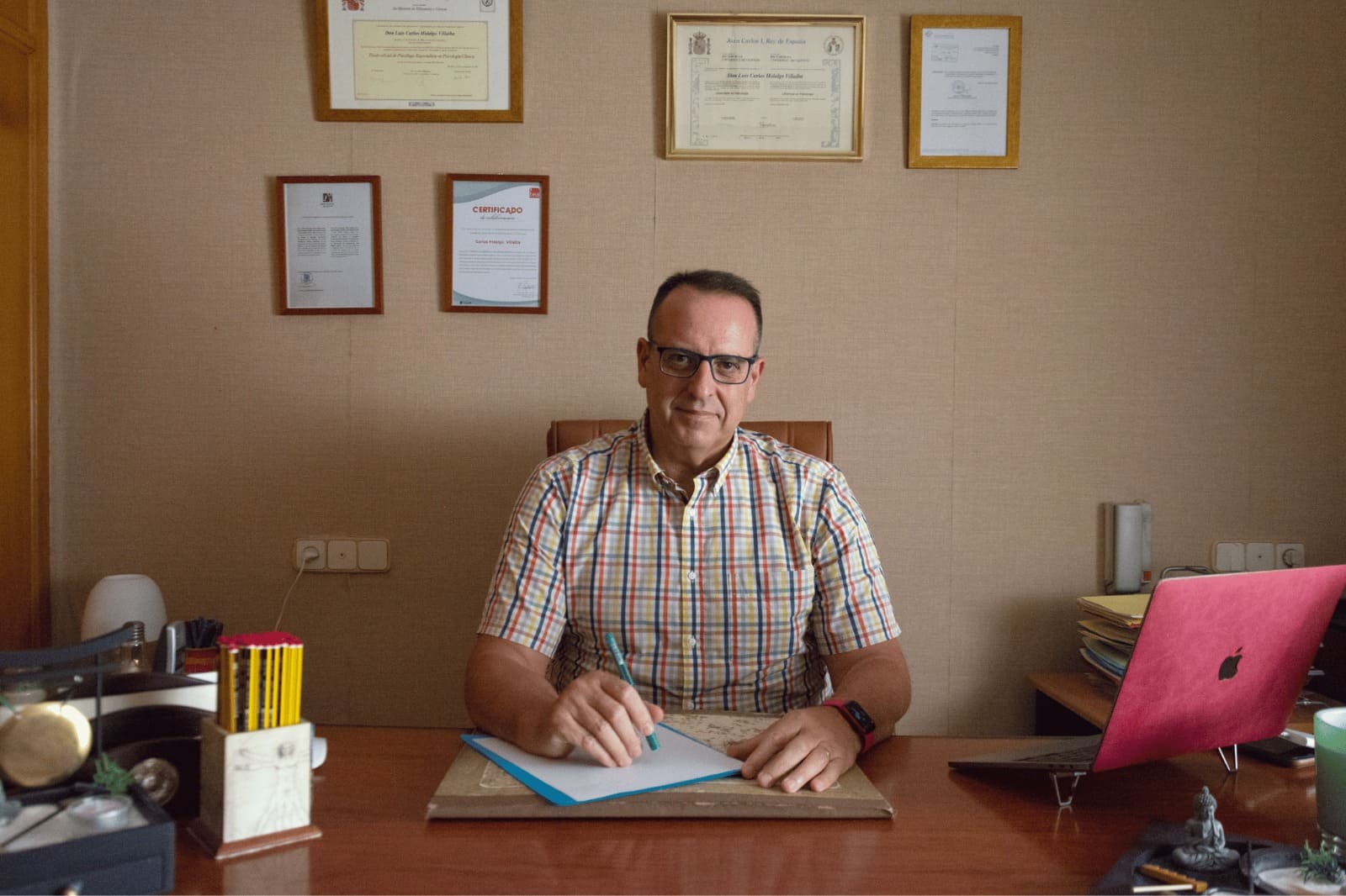 Carlos Hidalgo, psicólogo Cognitivo Conductual con gran experiencia, con consulta de psicología ubicada en Castellón, sentado en su despacho.